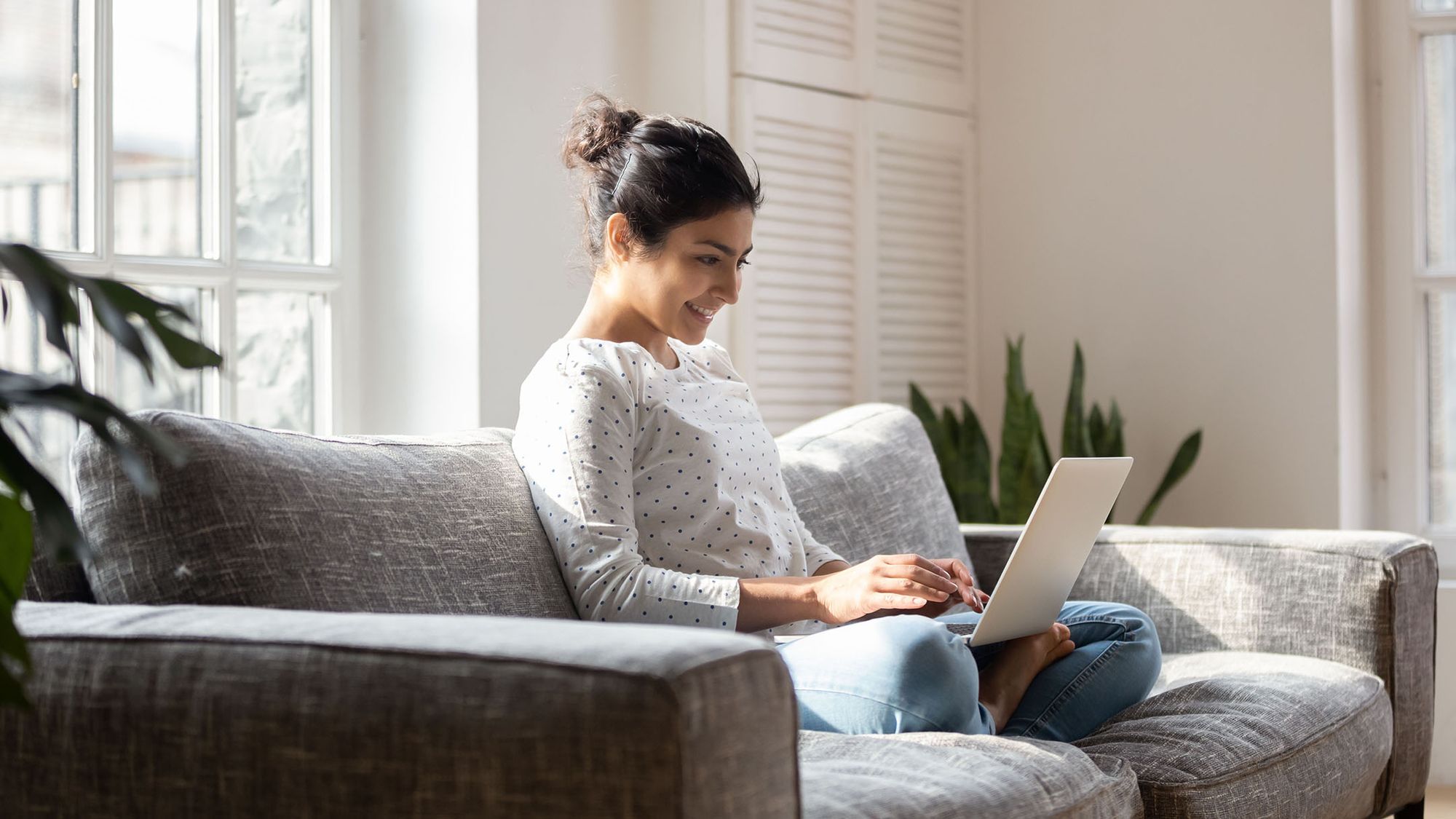 woman on laptop computer sitting on couch