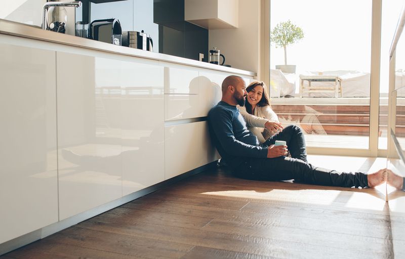 Happy couple drinking coffee talking about VA loan programs for buying their dream home