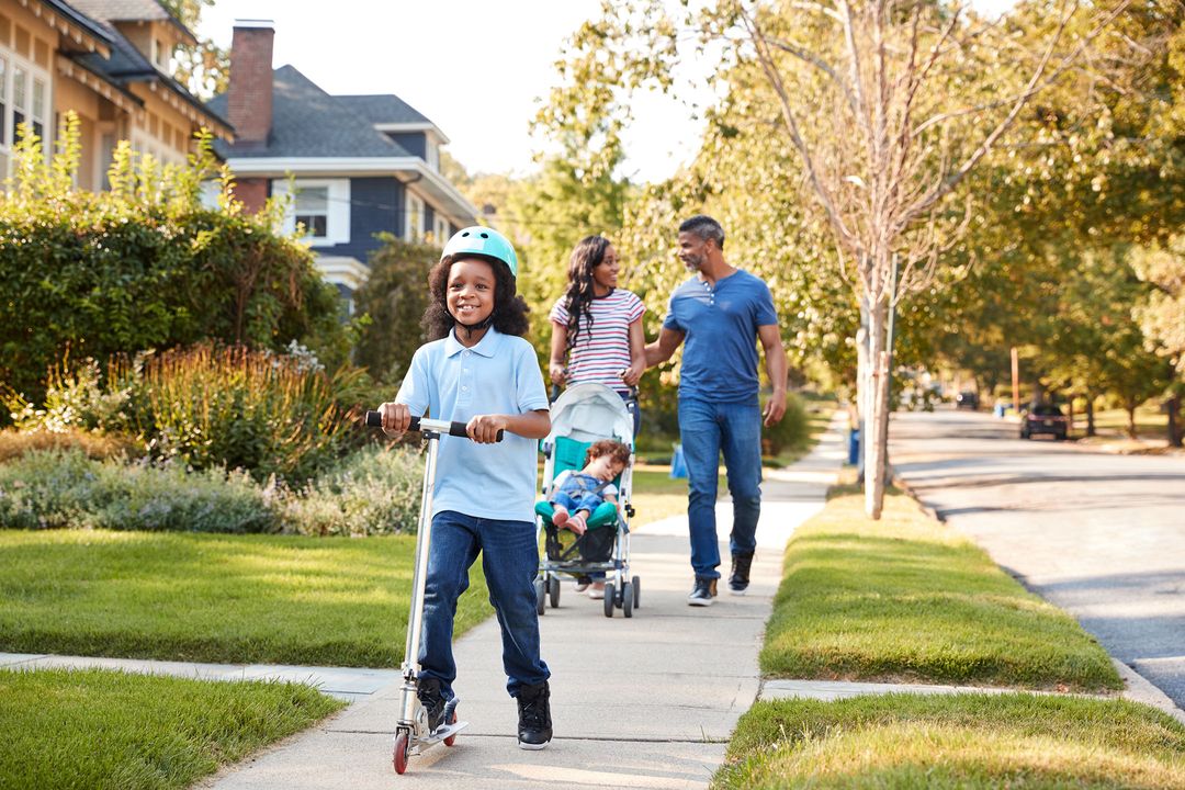 Nice, happy family of four walking and discussing plans to buy a home