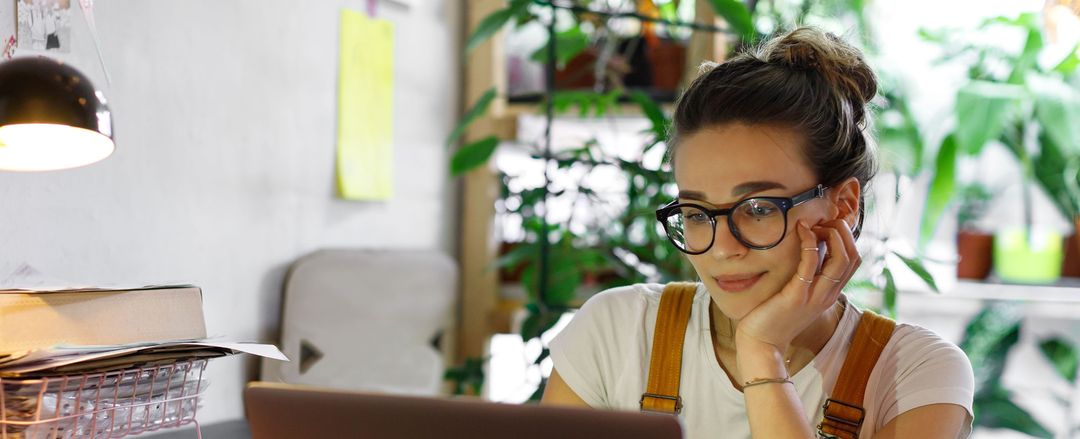 A Woman Wearing Glasses Reading Her Computer