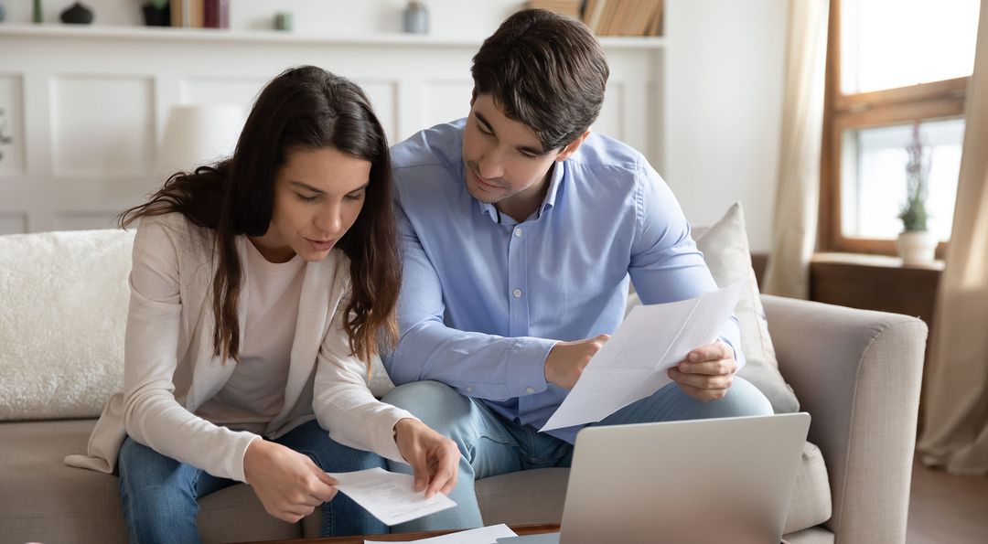 Man and woman couple review fee disclosures to see what they owe on a mortgage