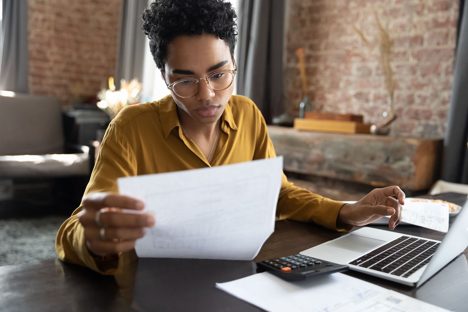 Woman Reading A Credit Report Received From A Mortgage Lender