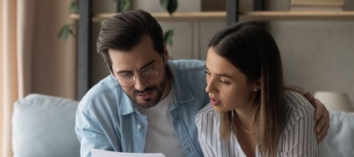 Husband and wife studying mortgage rates on a loan estimate