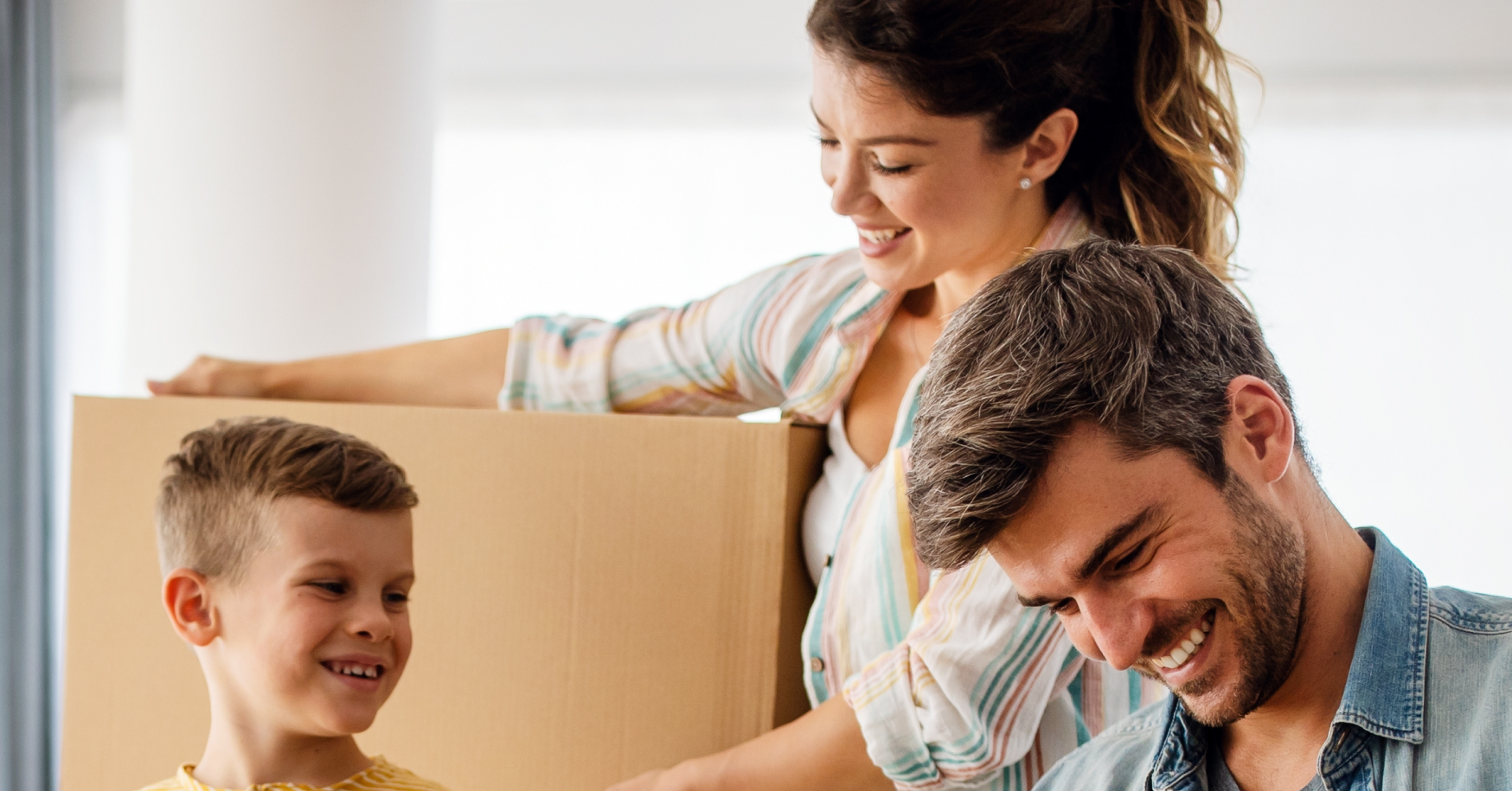 family bringing boxes into new home