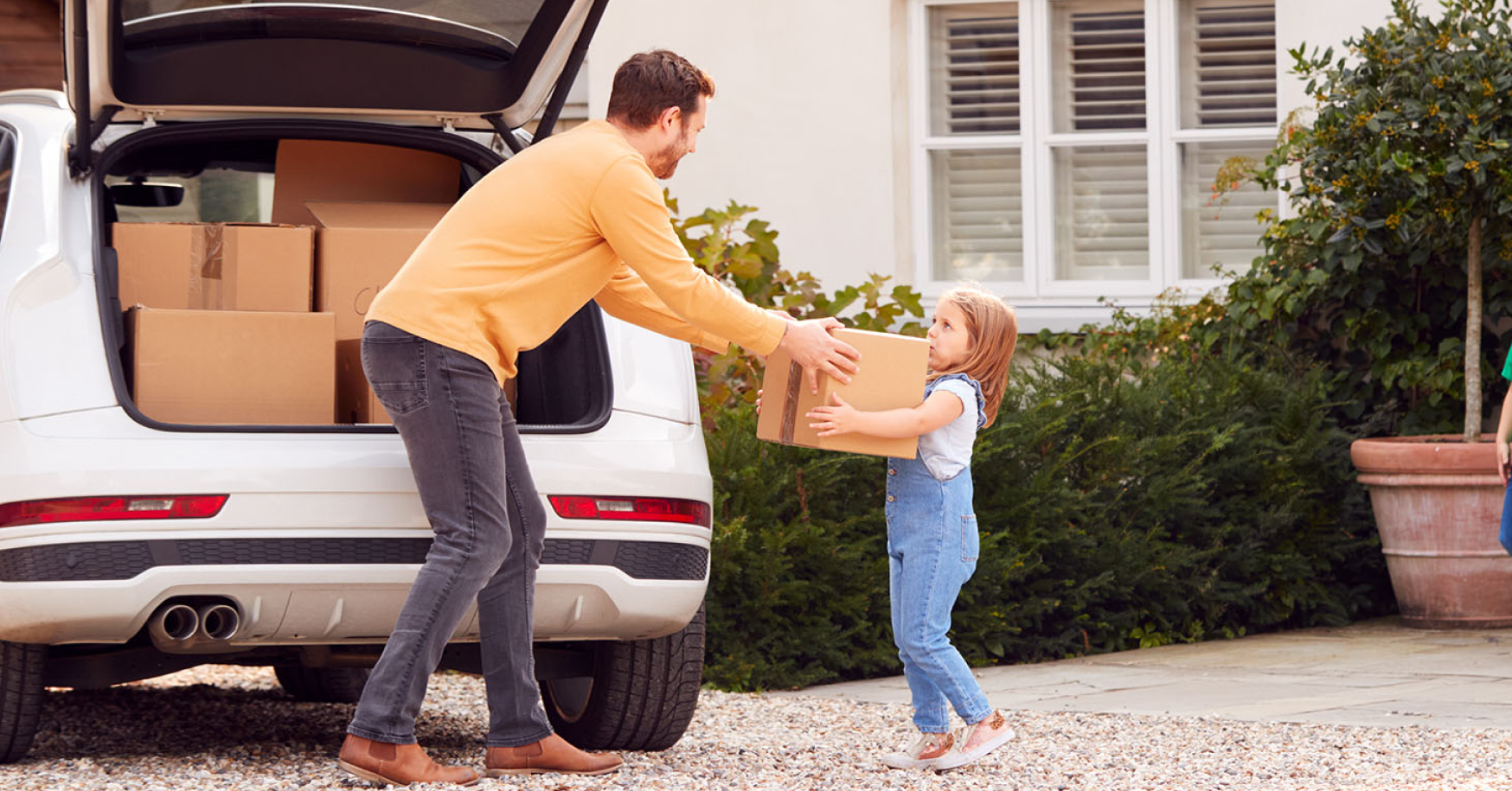 father handing moving box to daughter after they sold home using a real estate agent