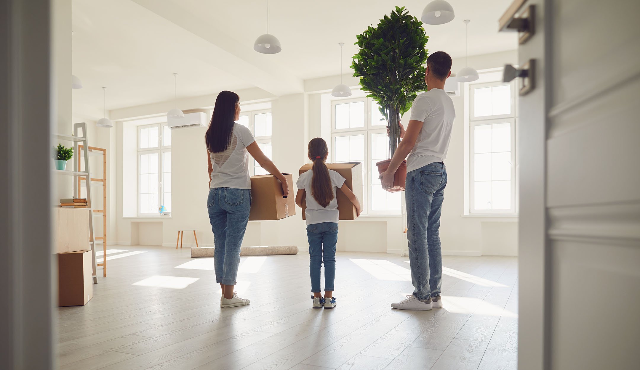 Family standing in empty room with boxes