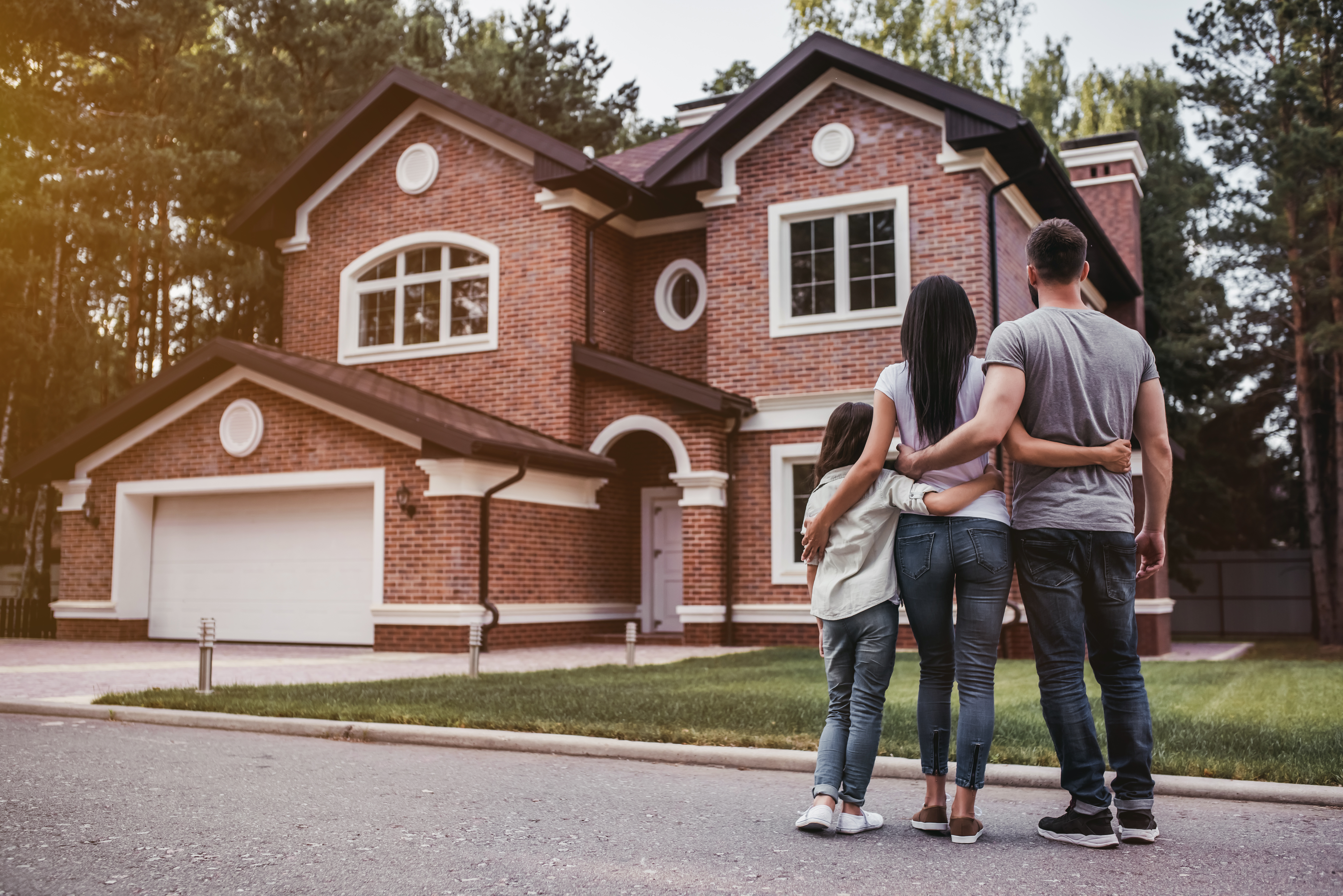 family standing in font of new home