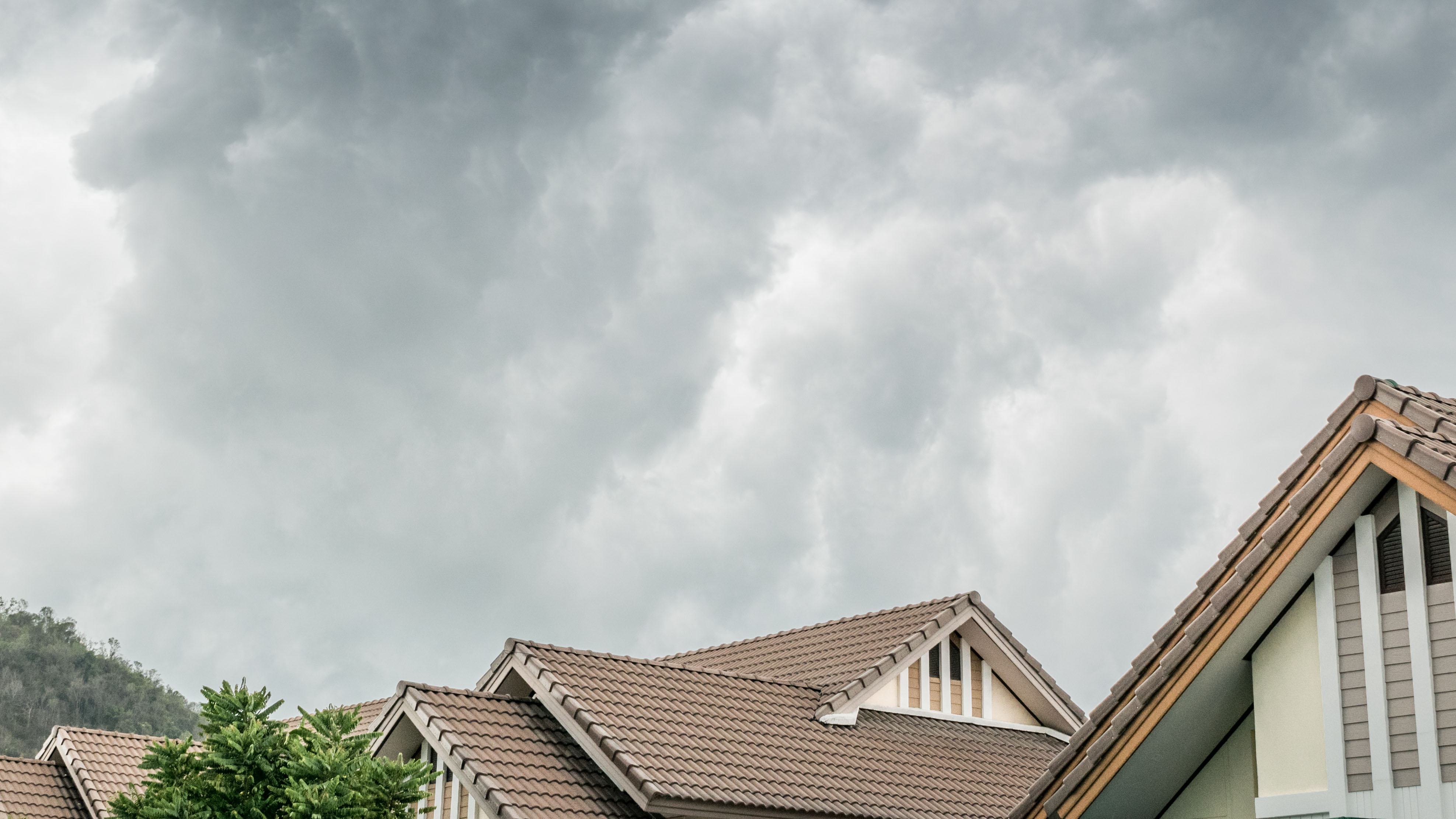Storm cloud over house with adequate home insurance coverage
